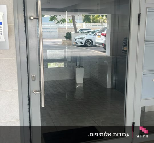 דלת זכוכית עם ידית מתכת בחניה